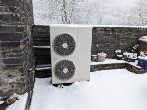 Vue enneigée d'une unité extérieure pour une pompe à chaleur à source d'air.