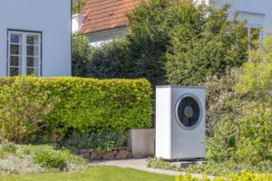 grande pompe à chaleur dans le jardin d'un ancien immeuble résidentiel