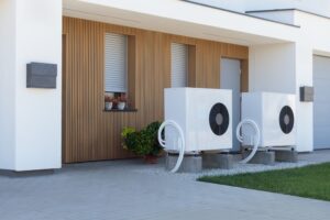 A pair of air source heat pumps, an eco-friendly home heating solution, installed at a contemporary residential property.