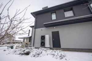 Outdoor heat pump unit mounted on the wall of a building