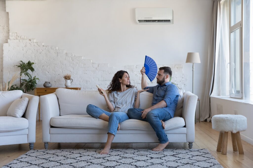wife,holds,remote,controller,turns,on,ac,,husband,cools,use