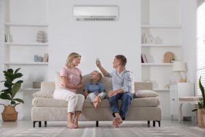 family,resting,together,on,sofa,at,home.,man,switching,on